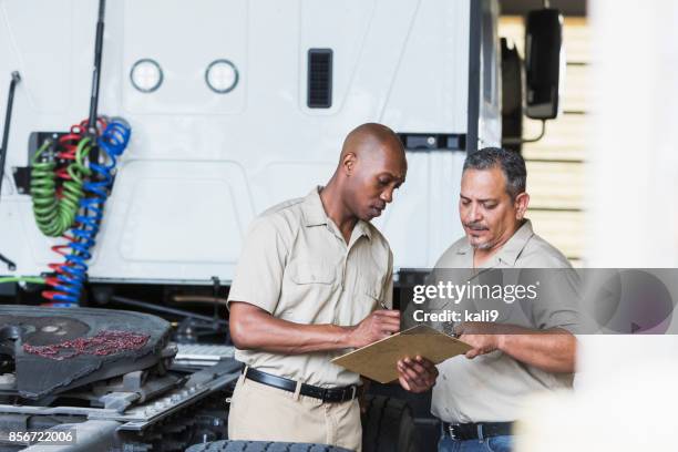 two men with semi-truck in garage - truck repair stock pictures, royalty-free photos & images