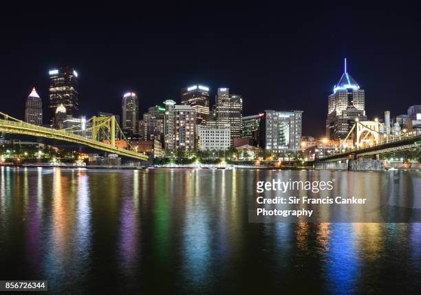 pittsburgh skyline illuminated with roberto clemente bridge and andy warhol bridge spanning the allegheny river at night in pennsylvania, usa - rivière allegheny photos et images de collection