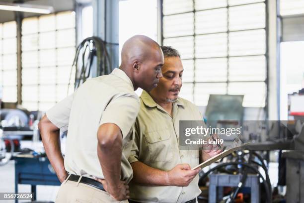 workers in truck repair shop - african lorry stock pictures, royalty-free photos & images