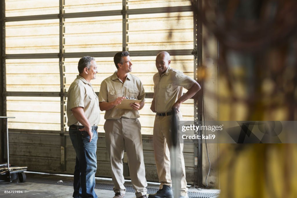 Three workers for trucking company having meeting