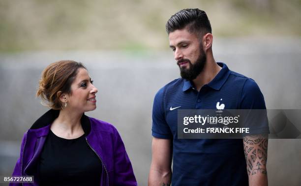 France's forward Olivier Giroud talks to French journalist and host Lea Salame during players' interviews within a training session in...