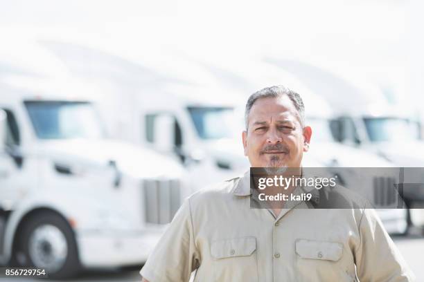 hispanic man standing in front of semi-trucks - fleet manager stock pictures, royalty-free photos & images