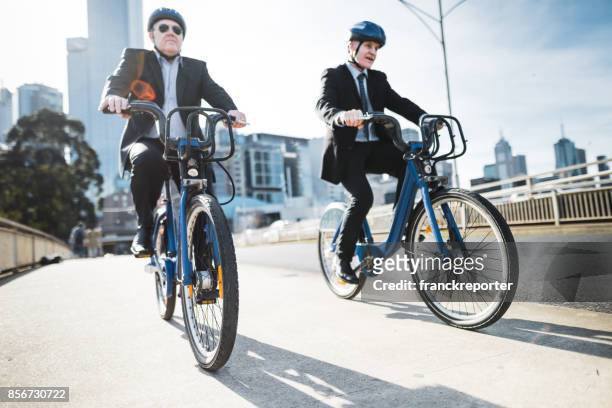 ondernemers woon-werkverkeer op de stad in melbourne in de schemering - partnership men bikes stockfoto's en -beelden