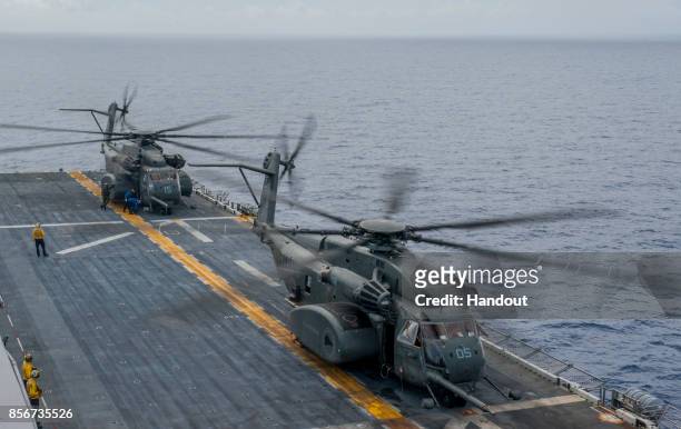 In this U.S. Navy handout, Sailors secure two MH-53E Sea Dragon helicopters assigned to the "Blackhawks" of Helicopter Mine Countermeasures Squadron...