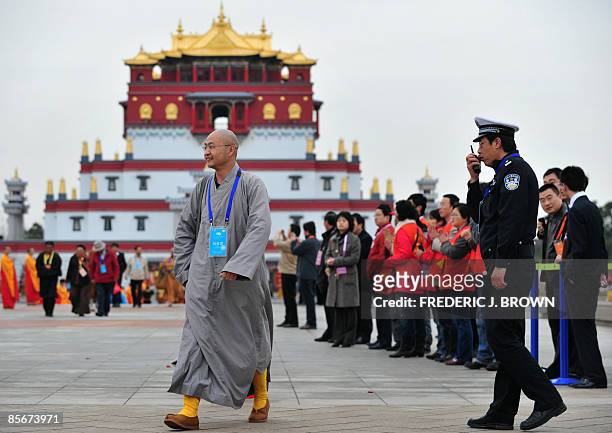 Policeman talks into his walkie talkie as Buddhist monks arrive for the opening session of the World Buddhist Forum on March 28, 2009 in Wuxi, in...