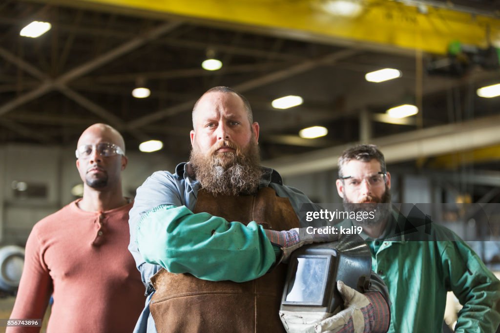 Multi-ethnic workers in metal fabrication plant