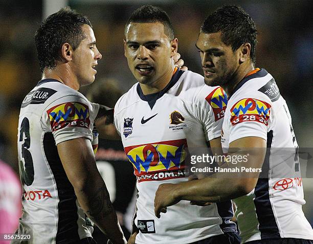 Steve Michaels and Karmichael Hunt celebrate with Alex Glenn of the Broncos after winning the round three NRL match between the Warriors and the...