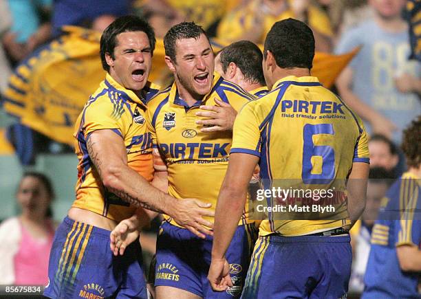 Ben Smith of the Eels celebrates with team mate Eric Grothe and Jarryd Hayne of the Eels after Grothe scored a try during the round three NRL match...