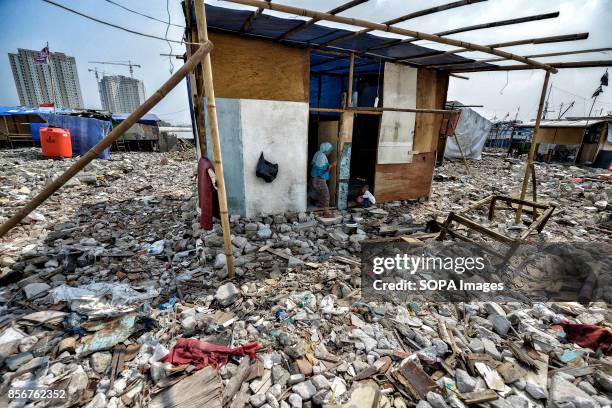 Woman and her son at their makeshift house among ruins and rubbish in the Pasar Ikan neighborhood of Jakarta. In April last year hundreds of soldiers...