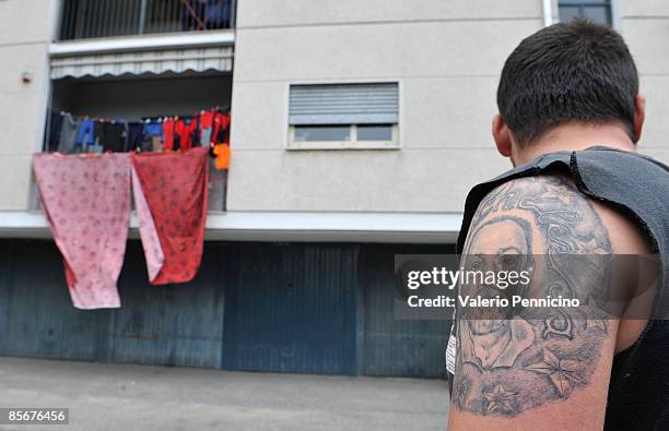 Man, who claims to be one of the sons of Michele Mongelli, displays his tattoo picturing Mongelli outside his home on March 28, 2009 in Turin, Italy....