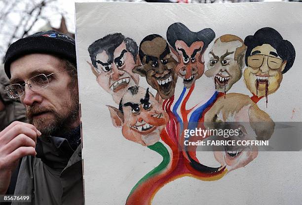 Demonstrator holds a cartoon representing the world leaders during a rally on March 28, 2009 in Geneva against the upcoming G20 summit in London. A...