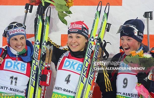 Italian Michela Ponza , winner German Magdalena Neuner and, French Marie Dorin , jubilate on the podium after the World Cup biathlon women's 10 km...