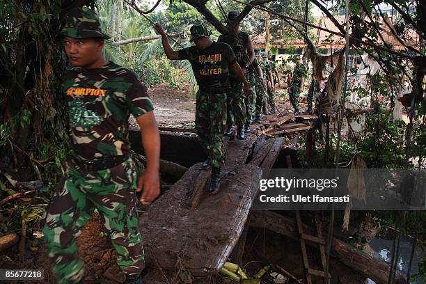 Indonesian soldiers prepare to search for dam-burst victims on March 28, 2009 in Ciputat, Indonesia. As the official death toll rises to 77,...