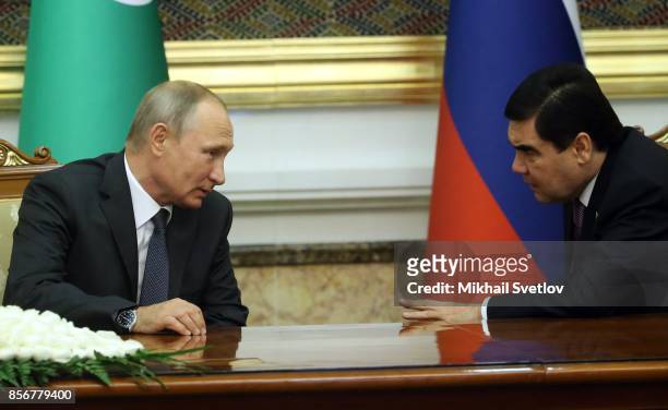 Turkmen President Gurbanguly Berdimuhamedow listens to Russian President Vladimir Putin during their meeting October 2, 2017 in Ashgabad,...