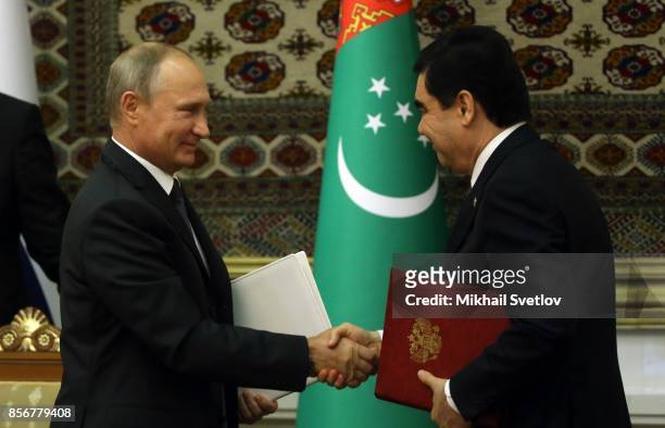 Turkmen President Gurbanguly Berdimuhamedow shakes hands with Russian President Vladimir Putin during their meeting October 2, 2017 in Ashgabad,...