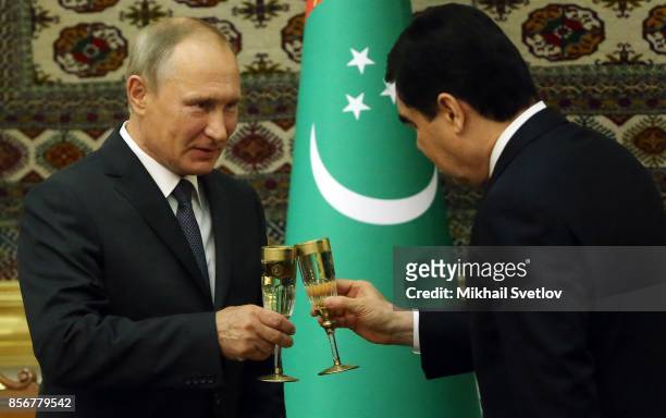 Turkmen President Gurbanguly Berdimuhamedow toasts with Russian President Vladimir Putin during their meeting October 2, 2017 in Ashgabad,...