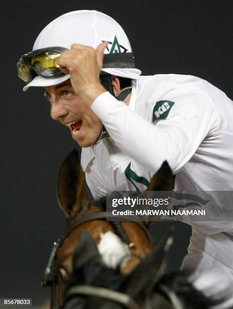 Jockey Aaron Gryder celebrates after leading Well Armed, owned by WinStar Farms LLC, to win the 6-million-dollar Dubai World Cup race in the Gulf...