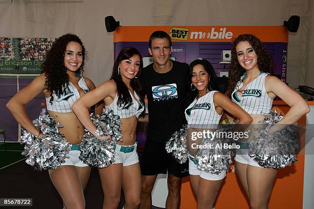 Tommy Robredo of Spain poses with the Florida Marlins Mermaids during day six of the Sony Ericsson Open at the Crandon Park Tennis Center on March...