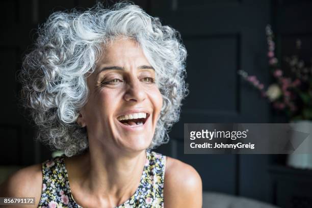donna con i capelli ricci grigi che distoccano lo sfondo e ridono - capelli grigi foto e immagini stock