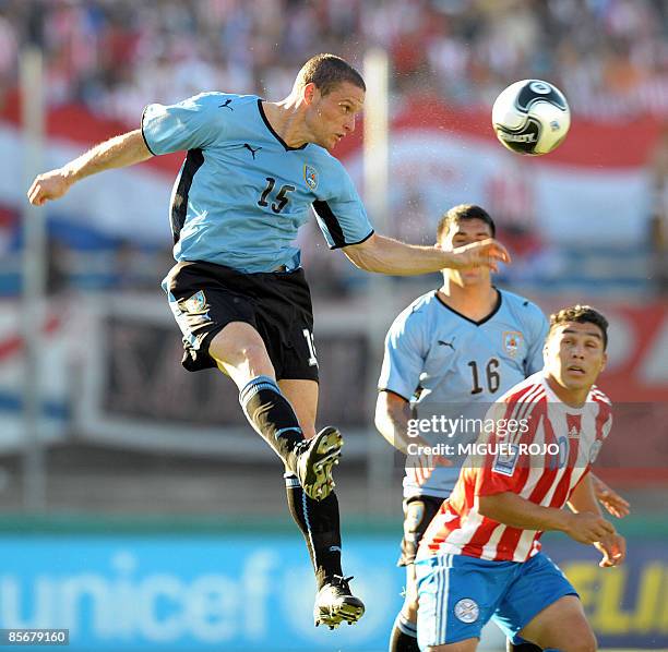 Uruguayan midfielder Diego Perez heads the ball next to Paraguayan forward Salvador Cabanas during their FIFA World Cup South Africa-2010 South...