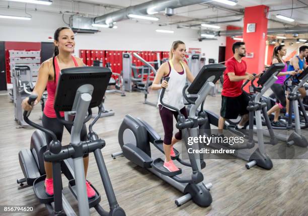 gruppe von menschen, die ausübung in der turnhalle auf cross-trainer - cross trainer stock-fotos und bilder