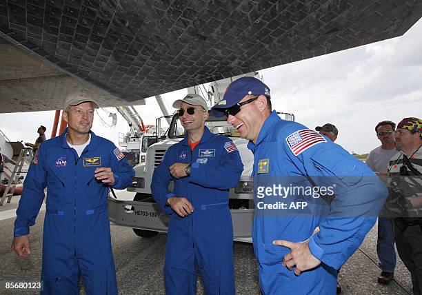 Space shuttle Discovery crew members mission specialist Steve Swanson , commander Lee Archambault and pilot Tony Antonelli stand under the shuttle...