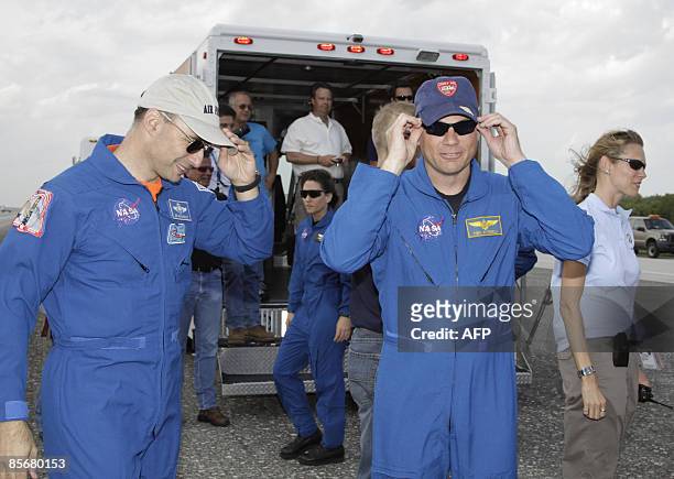 Space shuttle Discovery commander Lee Archambault and pilot Tony Antonelli put on hats after Discovery landed on March 28, 2009 at Kennedy Space...