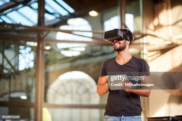 man using virtual reality simulator headset - realidade virtual imagens e fotografias de stock