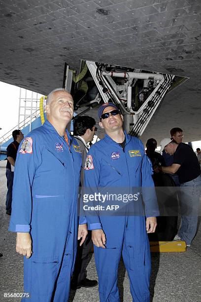 Space shuttle Discovery mission specialist John Phillips and pilot Tony Antonelli look at tiles on underside of the wing after Discovery landed on...