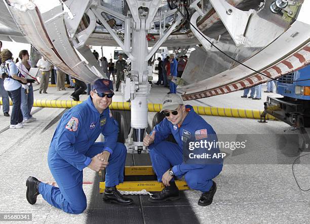 Space shuttle Discovery pilot Tony Antonelli and commander Lee Archambault pose near landing gear after Discovery landed on March 28, 2009 at Kennedy...