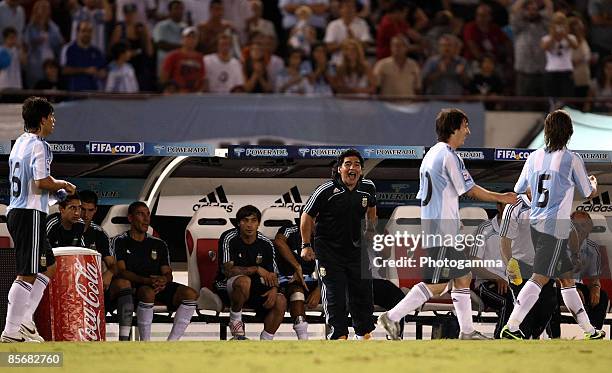 Argentine manager Diego Maradona looks on as Lionel Messi scores the first goal during the 2010 FIFA World Cup South African qualifier match between...