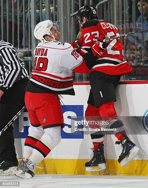 Ryan Bayda of the Carolina Hurricanes hits David Clarkson of the New Jersey Devils on March 28, 2009 at the Prudential Center in Newark, New Jersey....