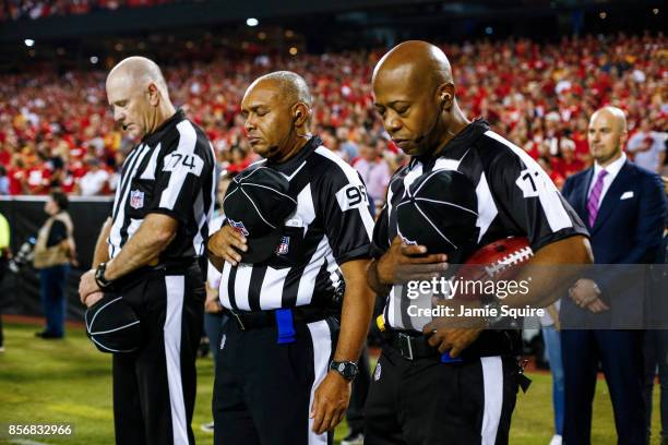 Referees bow their heads during a moment of silence for the victims of the Las Vegas shootings before the game between the Washington Redskins and...