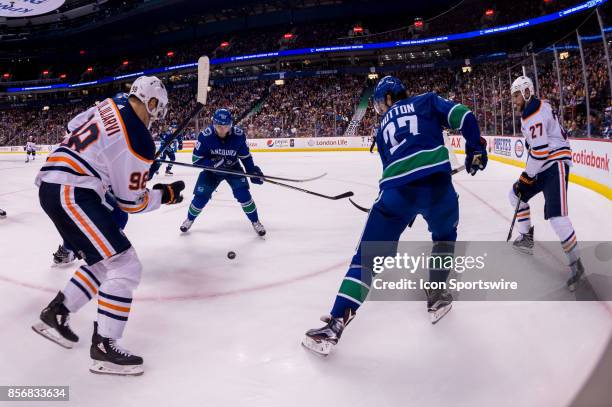 Vancouver Canucks center Markus Granlund watches the puck fall in front of Edmonton Oilers right wing Jesse Puljujarvi and Vancouver Canucks...