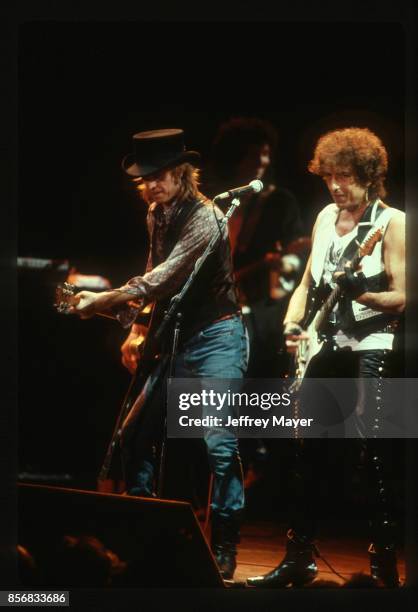 Tom Petty and The Heartbreakers perform with Bob Dylan in concert at The Forum on August 3, 1986 in Inglewood, California.