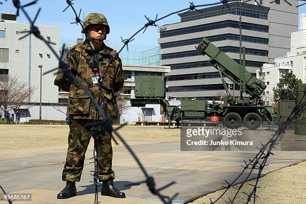 Member of Japan Ground Self-Defense Force stands guard in front of Patriot Advanced Capability-3 interceptors upon its compeletion of deployment at...