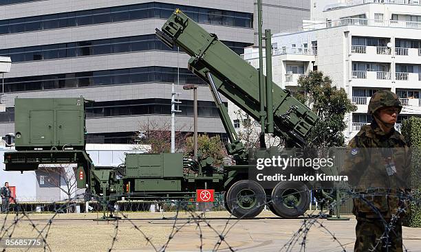 Member of Japan Ground Self-Defense Force stands guard in front of Patriot Advanced Capability-3 interceptors upon its compeletion of deployment at...