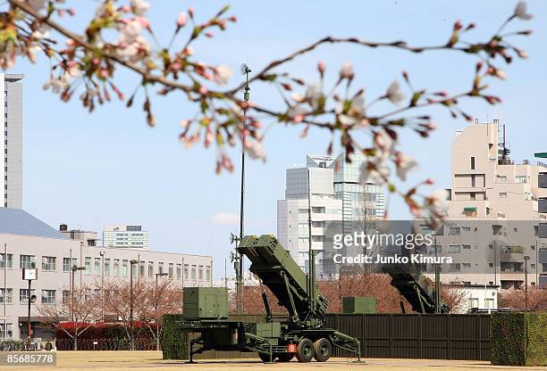 Cherry blosoms bloom in front of Patriot Advanced Capability-3 interceptors upon its compeletion of deployment at Ministry of Defense on March 29,...