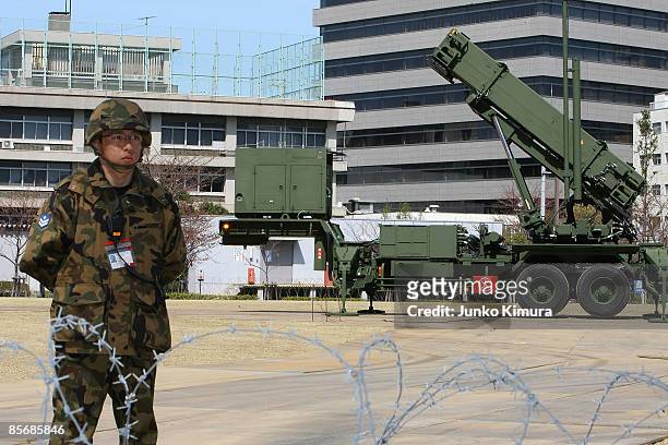 Member of Japan Ground Self-Defense Force stands guard in front of Patriot Advanced Capability-3 interceptors upon its compeletion of deployment at...