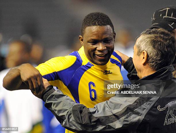 Gabon's Ernest Akoussaga celebrates with the team's coach Alain Giresse of France after winning their WC2010 qualifiying football match against...