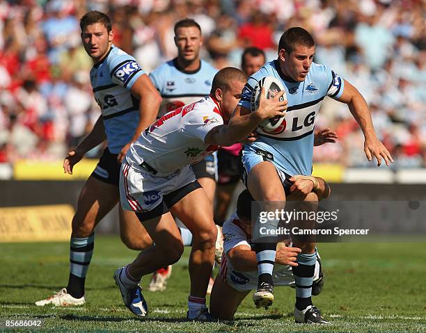 Tony Caine of the Sharks is tackled during the round three NRL match between the St George Illawarra Dragons and the Cronulla Sharks at WIN Jubilee...