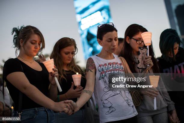 Mourners attend a candlelight vigil at the corner of Sahara Avenue and Las Vegas Boulevard for the victims of Sunday night's mass shooting, October...