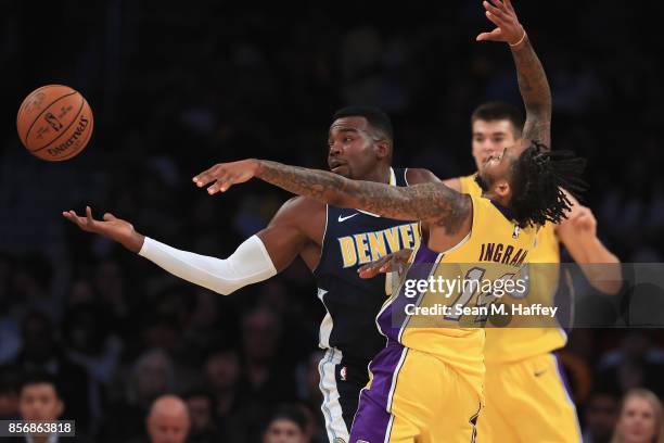 Brandon Ingram of the Los Angeles Lakers battles Paul Millsap of the Denver Nuggets for a loose ball during the first half of a preseason game at...