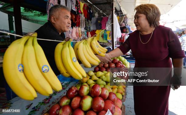 Picture taken on September 20, 2017 shows Kyrgyz rights activist and presidential candidate Toktayim Umetalieva meeting with local residents at...