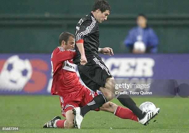 Chris Pontius of D.C. United is tackled by Daniel Woolard of the Chicago Fire during an MLS match at RFK Stadium on March 28, 2009 in Washington, DC....