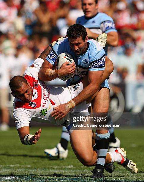 Bryan Norrie of the Sharks fends off Dan Hunt of the Dragons during the round three NRL match between the St George Illawarra Dragons and the...