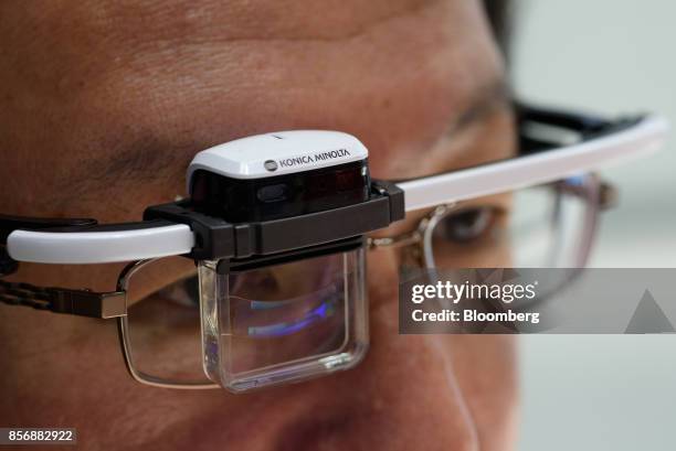 An employee demonstrates Konica Minolta Inc.'s Wearable Communicator at the company's booth at the CEATEC Japan 2017 exhibition in Chiba, Japan, on...