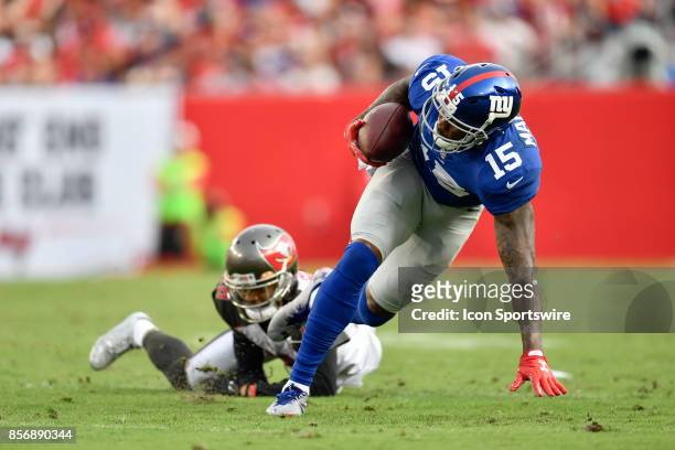 New York Giants wide receiver Brandon Marshall tries to keep his balance as he breaks through a tackle during an NFL football game between the New...