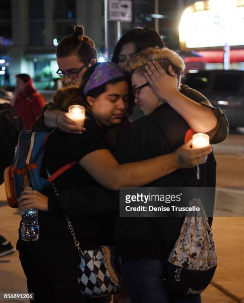 Gabby Phillips, Sam Alworth, Ana Preciado and Evan Dixon embrace during a vigil on the Las Vegas strip, for the victims of the Route 91 Harvest...
