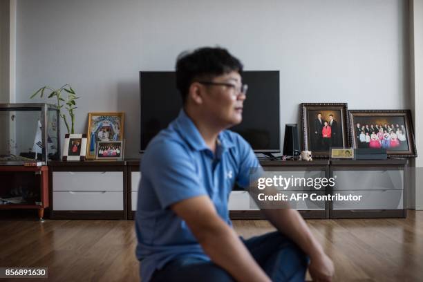 Photo taken on August 23, 2017 shows Kim Kyeong-Bok sitting in the apartment he shares with his wife Huynh Thi Thai Muoi in Gwangju. There are some...